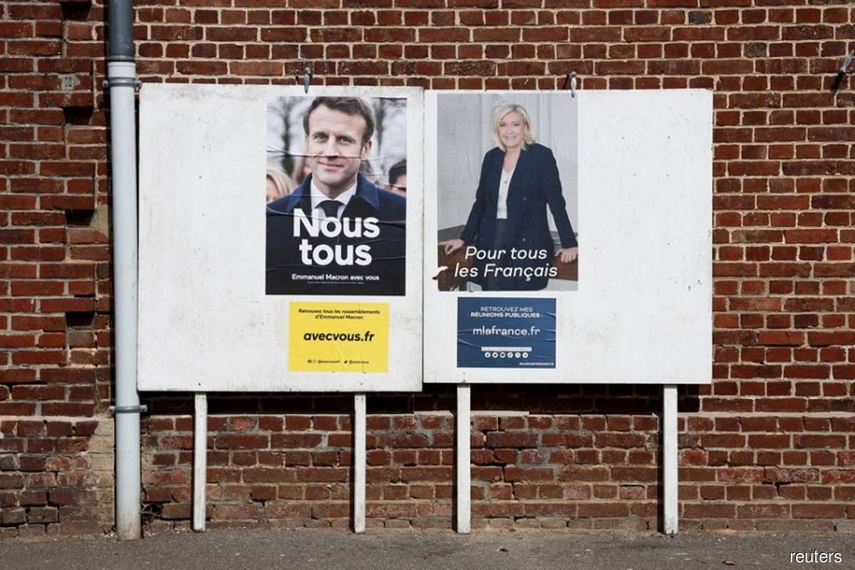Official campaign posters of French presidential election candidates Marine le Pen, leader of French far-right National Rally (Rassemblement National) party, and French President Emmanuel Macron, candidate for his re-election are displayed on an official billboard in Montchevreuil, France on April 20, 2022. (Photo by Benoit Tessier/Reuters filepix)